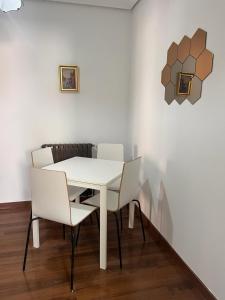 una mesa blanca y sillas en una habitación con pared en Apartamento Buena Vista, en Cehegín