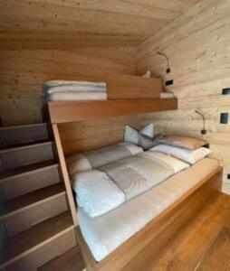 a bed in a wooden room with at YAK Hauesl in Fleres