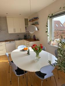 a kitchen with a white table with a vase of flowers on it at Vila Åkarp in Åkarp