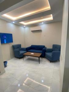 una sala de espera con sillas azules y una mesa en بيست تريب فالنسيا en Jazán