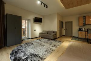 a living room with a couch and a rug at Discovery Garden apartments in Khmelnytskyi