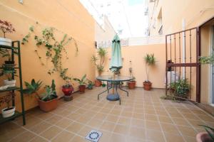 un patio con mesa y macetas en Luchana 15, en Málaga