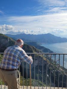 a man standing on top of a mountain overlooking the water at Luna D'Agerola in Agerola