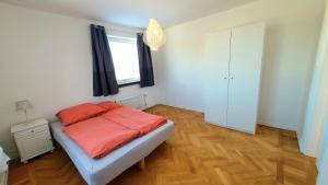 Smålands gemütliche Apartments direkt am Fluss في Högsby: غرفة نوم مع سرير وملاءات برتقالية ونافذة
