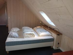een bed met vier kussens en een lampje erop bij Chez Fanch in Lampaul