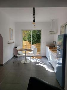 a kitchen with a table and chairs in a room at L'entre-deux in Périgueux