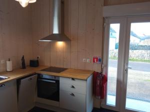 uma cozinha com fogão forno superior ao lado de uma janela em Chez Fanch em Lampaul