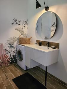a bathroom with a washing machine and a mirror at L'entre-deux in Périgueux +24 photos