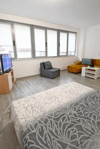 a room with a bed and a couch and a tv at Lazy studio in Sofia
