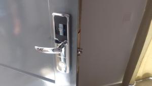 eine Metalltür mit Türgriff an einer Badezimmertür in der Unterkunft Apartamentos Santiago - Tarrafal in Tarrafal