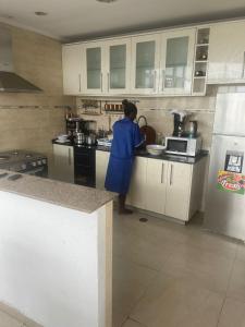 une personne debout dans une cuisine préparant des repas dans l'établissement Sunny Luanda, à Luanda