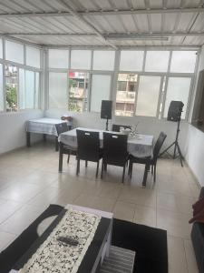 a living room with a table and chairs and windows at Sunny Luanda in Luanda