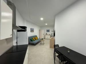 eine Küche und ein Wohnzimmer mit einem Sofa und einem Tisch in der Unterkunft Casa Elias - Costa Calma Sun & Beach in Costa Calma