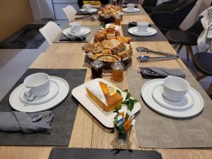 RiantecにあるMon petit coin de Bretagneの長い木製テーブル(食べ物、カップ、パン付)