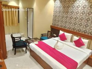 een slaapkamer met een groot bed en een rode deken bij THE SKYLITE HOTEL & BANQUET in Ara