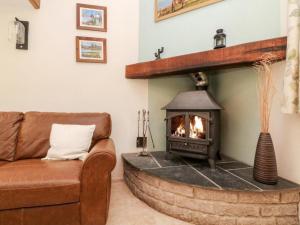 sala de estar con chimenea y sofá en Pheasants Roost With Indoor Pool In Devon en Broadwoodkelly