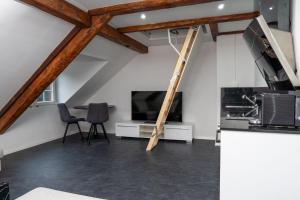 ein Wohnzimmer mit einem TV, einem Tisch und Stühlen in der Unterkunft Kirchweg 22 8750 Glarus in Glarus