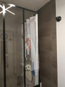 a glass shower door with a shower curtain with aookyooky at Grand studio idéalement situé in Chambray-lès-Tours