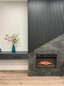 a fireplace in a room with a vase of flowers at LEOGRAND Apartments on Virmenska 14 in Lviv +1 photo