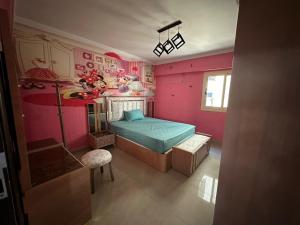 ein Schlafzimmer mit einem Bett und einer rosa Wand in der Unterkunft Palace Luxury Rooms in Kairo
