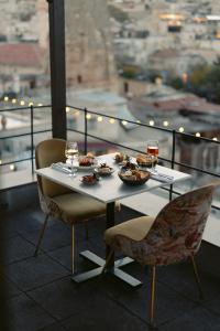 una tavola con piatti di cibo e bicchieri di vino di Carus Cappadocia a Göreme