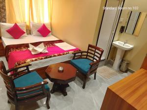 Ara的住宿－THE SKYLITE HOTEL & BANQUET，卧室配有一张床和一张桌子及椅子