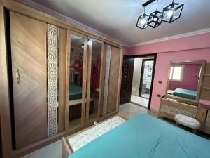 Un dormitorio con una cama azul y una pared rosa en Palace Luxury Rooms en El Cairo
