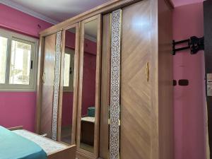 Schlafzimmer mit einem Holzschrank und Glastüren in der Unterkunft Palace Luxury Rooms in Kairo