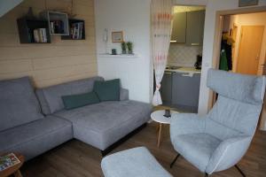 ein Wohnzimmer mit einem Sofa und 2 Stühlen in der Unterkunft Vinnenhus Wohnung 06 in Cuxhaven