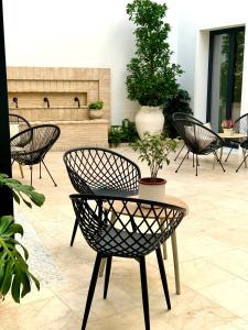 un patio con sillas y una mesa con una maceta en Casa Boutique Navarro, en Montilla