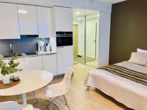 Cet appartement comprend une chambre avec un lit et une table ainsi qu'une cuisine. dans l'établissement Studio VIP - close to airport and Tikkurila train station, à Vantaa