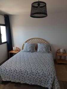 a bedroom with a bed with a blue comforter at Casa dos Avós in Fajã da Ovelha