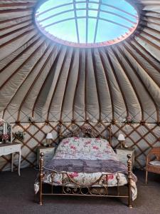 东迪勒姆Gingerbread Cottage Yurts的蒙古包里有一张床的卧室