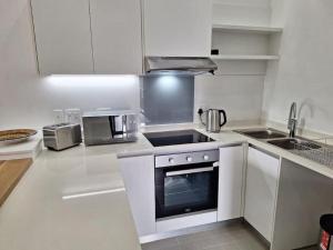 a kitchen with white cabinets and a stove top oven at Simbithi Golf Estate Luxury Apartment in Ballito