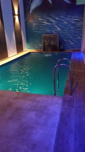 een zwembad met een blauw licht in een gebouw bij Villa avec piscine in Plage de Mehdia