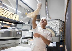 a man in a kitchen holding up a napkin at Casa Relax nel centro storico con posto auto in Vico Equense