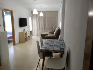 uma sala de estar com uma mesa e um sofá em Apartamento a 150m de la playa en Torrevieja em Torrevieja