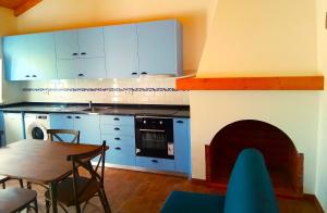 uma cozinha com uma mesa e uma cozinha com uma lareira em VALE DE GAIOS - CASARÃO by Stay in Alentejo em São Luis