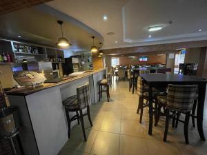 ein Restaurant mit einer Bar mit Stühlen und Tischen in der Unterkunft The Chesterfield Hotel in Lagos