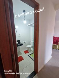 uma casa de banho com um WC e uma porta de vidro em Apartamento em Cabo Frio