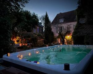 a large swimming pool with green water at night at Maison d'hôtes La Source in Magny-les-Hameaux