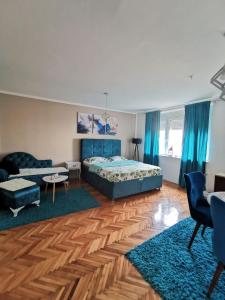 a bedroom with a bed and a living room at City Center Apartment JOTIC in Pirot