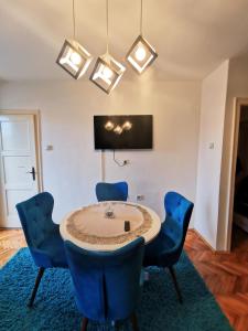 a dining room with a table and blue chairs at City Center Apartment JOTIC in Pirot