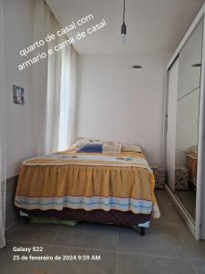 um quarto com uma cama num quarto com uma janela em Apartamento em Cabo Frio