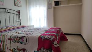 - une chambre avec un lit et une couverture colorée dans l'établissement Amplio piso en Pontedeume, à Pontedeume