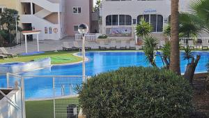 a large swimming pool in a building with palm trees at Residencial Chayofa, 1 dormitorio in Chayofa