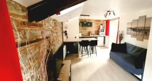 Il comprend un salon et une cuisine avec un mur en briques. dans l'établissement Appartement de Charme - Centre Ville, à Châteaubriant