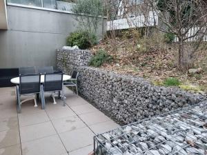 uma mesa e cadeiras sentadas ao lado de uma parede de pedra em Elegant Suites Murten em Murten