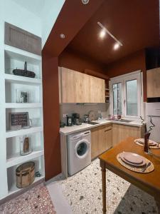 a kitchen with a washing machine and a table at Apartment near Metro + Port in Piraeus