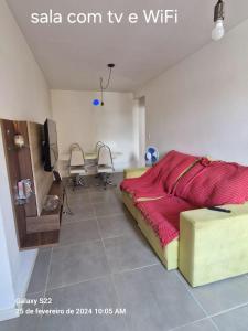 1 dormitorio con 1 cama, mesa y sillas en Apartamento en Cabo Frío